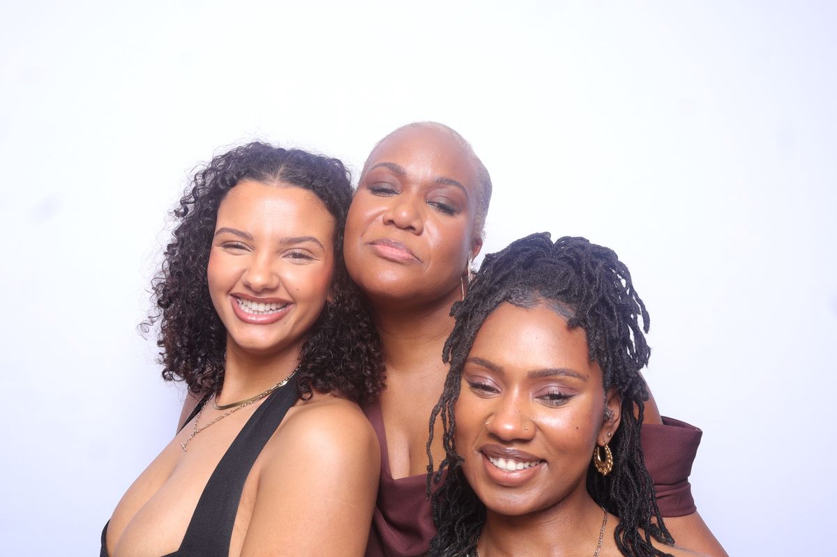 Three guests smiling together in the photobooth